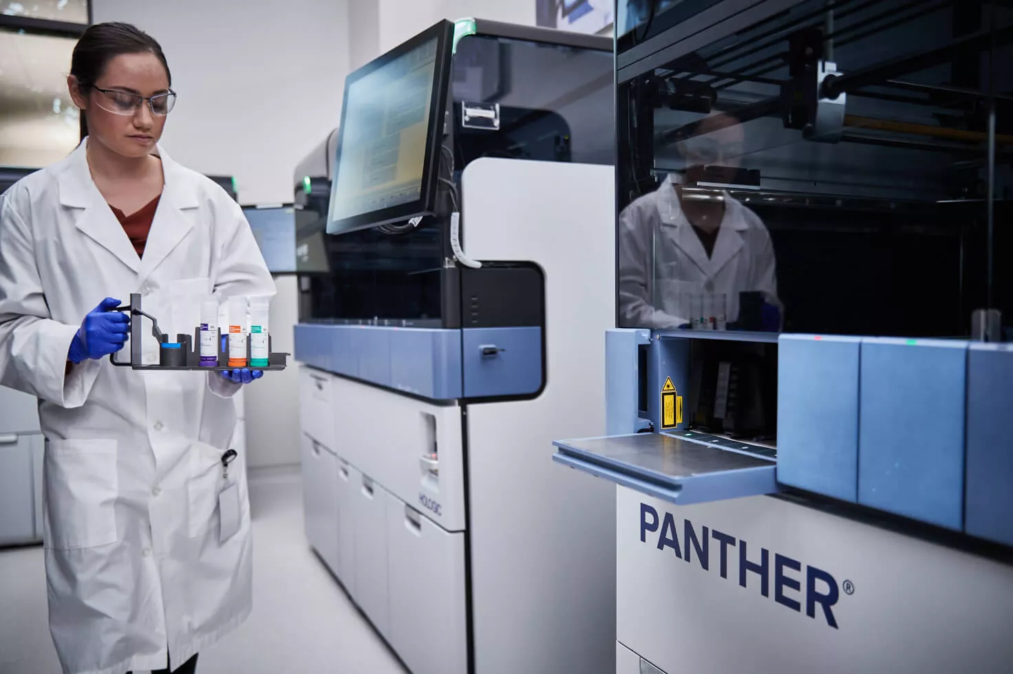 Técnico de laboratorio con una bandeja de viales en un laboratorio